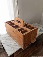 Large handmade wooden toolbox shown closed with visible compartments and handle.