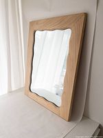 Full view of the large wood framed wall mirror showing the wavy edge detail around the mirror glass.