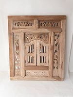 Front view of ornate wooden frame showing closed window shutter design.