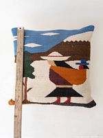 Front of pillowcase with ruler alongside showing approximately 20 inch length measurement. Depicts Native-style woven artwork of a person in a white hat, standing by a green tree with mountainous background and blue sky with clouds.