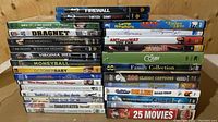 Stack of DVDs and Blu-rays showing titles like 'Firewall', and assorted family collections and movies.