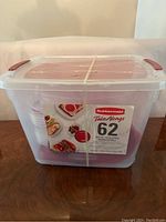 Clear large storage box containing all 62 pieces of the Rubbermaid TakeAlongs containers securely strapped.