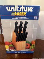 Front of box showing Wiltshire Laser 13-piece cutlery block set with wooden block and black-handled knives.