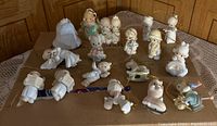 Photo showing 17 Precious Moments porcelain Christmas tree ornaments including angels, children in winter and holiday attire, and holiday animals such as dog and horse figurines.