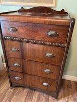 Front view of the full dresser showing the wood grain, brass shell-style drawer pulls and waterfall design.
