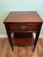 Full front view of the solid wood side table showing drawer and shelf