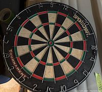 Front view of Sportcraft Tournament dart board positioned on a vertical surface, showing the numbered sections and scoring rings.