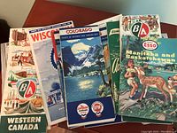 Photo showing a collection of colorful vintage road maps proudly sponsored by various petroleum companies like Chevron, BA Imperial Esso, and others. Includes maps from Western Canada, Colorado, Manitoba, Saskatchewan.