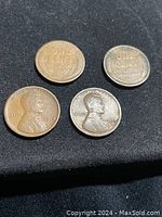 Four 1918 Lincoln Wheat pennies on obverse showing Abraham Lincoln profile with date and liberty inscriptions.