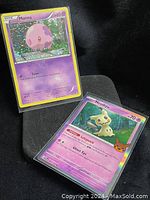 Photo of 2 rare holo purple Pokémon cards: Munna and Mimikyu, both in protective sleeves.