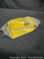 Plastic bag with a stack of Pokémon cards showing front yellow borders and card art.