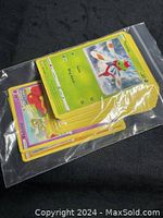 Photo of Pokémon cards featuring visible front cards with characters Flabébé and others in colorful artwork inside a clear resealable plastic bag.