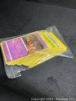 Pokémon cards inside a clear plastic bag, showing the front side of various cards with different characters, energies, and stats