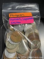 Plastic bag labeled 'Foreign Korean, Japanese, China' containing a collection of various coins with some having holes in the center.