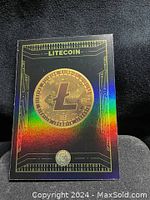 Front of holographic Litecoin card showing Litecoin symbol and binary circuit design with rainbow holographic effect.