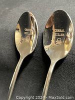 Photo showing the front views of two engraved spoons with "Cereal Killer" text and skull graphic on the bowl