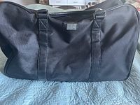 Front view of the black Hugo Boss carry-on bag showing canvas material and handles.