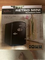 Box of Koalatron Retro Mini Thermoelectric Cooler showing the product and key features like 4-liter capacity and 120V power compatibility.