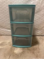 Front view of the plastic storage unit showing three stacked drawers with teal accents.