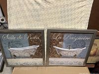 Two framed prints featuring vintage clawfoot bathtubs with French text against decorative backgrounds.