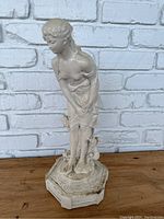 Full view of the 19-inch concrete statue showing the girl leaning forward and the polygonal base.