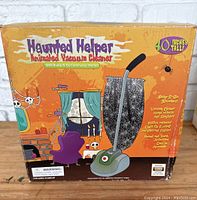 Box front showing Haunted Helper Animated Vacuum Cleaner branding and Halloween theme graphics.