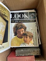 A Look magazine JFK Memorial Issue showing cover photo of Jacqueline Kennedy with child and a few vintage hardback books at the bottom of the box.