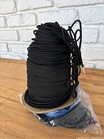Photo of black paracord spool and visible portion of spool.