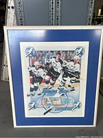 Full framed poster with blue matte showing three Tampa Bay Lightning hockey players and autographs.
