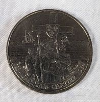 Front side of the 1984 Jacques Cartier Canadian dollar coin showing Jacques Cartier with cross and ships in the background.