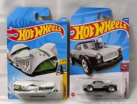 Lot showing two Hot Wheels cars new in blue packaging, Clear and Dagger and The Nash models