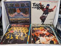 Four vinyl records stacked vertically showing covers from Styx, Fiddler on the Roof, Attilio Honey, and Twymes