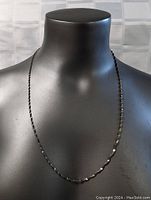 Full view of the sterling silver necklace displayed on a black mannequin torso showing the length and chain style.