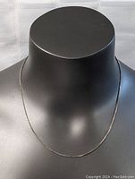 Sterling silver necklace displayed on black mannequin, showing full length and design.