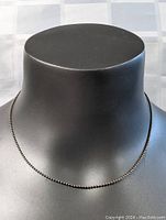 Front view of the sterling silver beaded necklace on black necklace display bust, showing the full chain length and bead style.