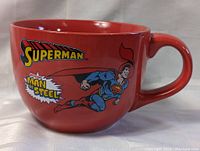Front side of red Superman oversized mug showing 'Superman' logo, 'Man of Steel' text, and Superman flying artwork.