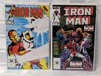 Two vintage Iron Man Marvel comic books side by side in protective sleeves, showing front covers.