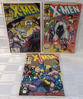 Photo showing three Marvel X-Men comic books in plastic protectors. Two issues of The Uncanny X-Men (#121 and #122) and one Classic X-Men issue with cover text 'Pyrrhic Victory'.