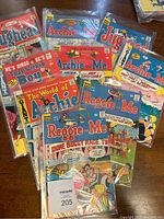 Lot of 9 assorted vintage Archie series comic books in protective sleeves, showing front covers with characters and titles.