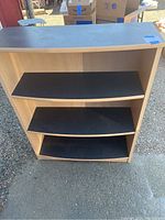 Front view of medium sized wooden bookshelf with three black shelves and black top