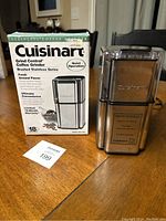 Front view showing Cuisinart coffee grinder and original box on wooden surface.