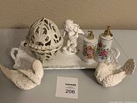 7 piece lot of white decorative porcelain items including swan figurines, cherub, lidded basket, dispensers, and tray