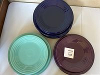 Three stacks of Fiesta plates: teal on left, navy blue at top, purple on right