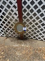 Full view of modern gold sunburst mirror with metal rods and mesh lattice extending from central round mirror.