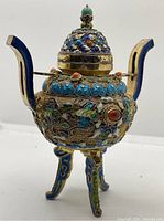 Angled view of three-legged incense burner with domed lid in place