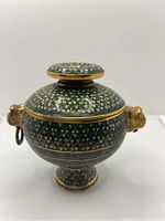 Front angle view of the green cloisonné trinket box showing detailed gold swirls and white dots.