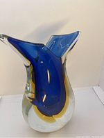 Front angled view showing deep blue and yellow colors inside clear glass and curved opening edges.