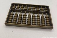 Mini copper abacus, seen from a top angle, showing 7 rows of copper beads in the larger section and 2 rows in the smaller section.
