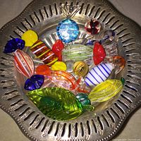 Top view of colorful hand blown glass candies in vintage silver plated pedestal dish