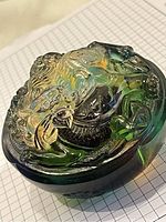 Close-up photo of green glass paperweight showcasing detailed dragon sculpting and coloration.